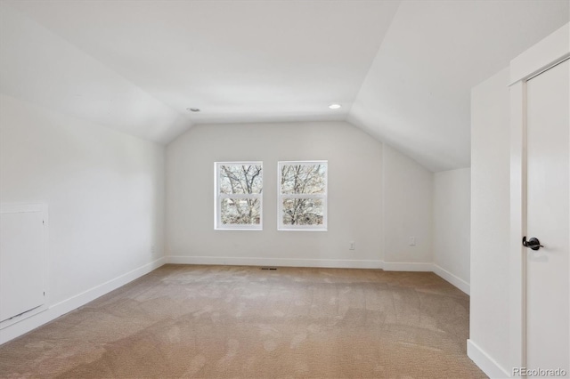 bonus room featuring lofted ceiling, carpet, and baseboards