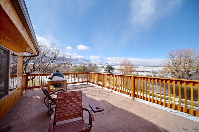 snow covered patio with a mountain view