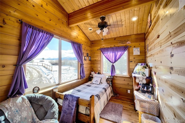 bedroom featuring light hardwood / wood-style floors, wooden ceiling, wooden walls, and vaulted ceiling