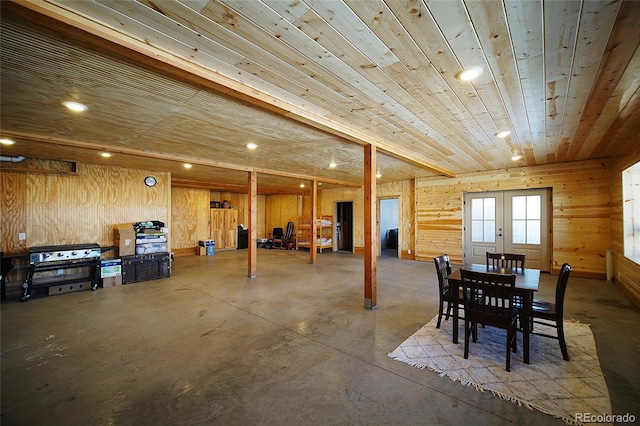 dining area with concrete flooring, french doors, wooden ceiling, and wood walls