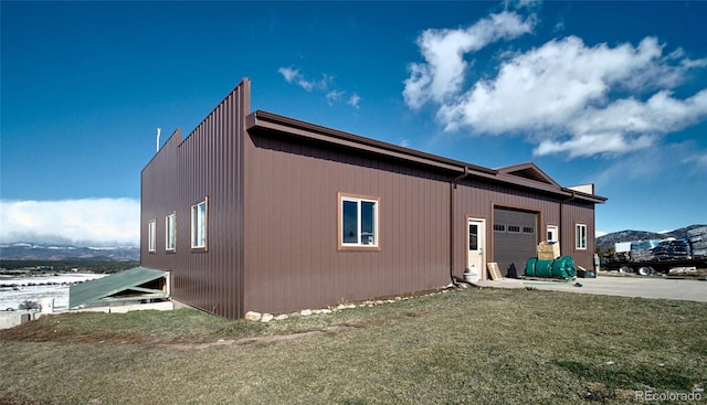 view of side of property with a lawn and a garage