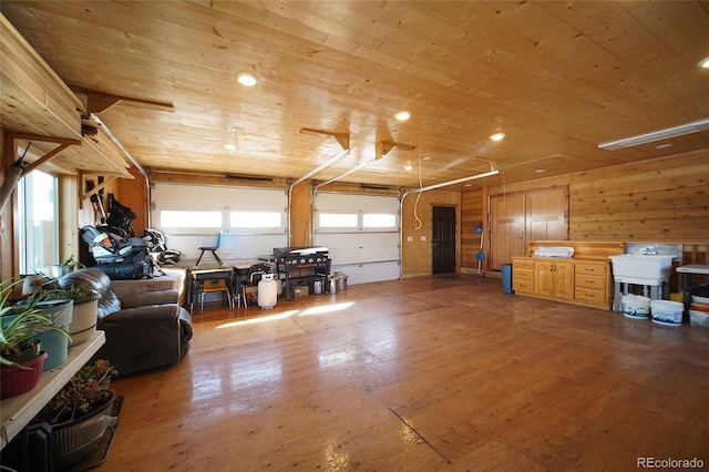 garage featuring wood walls, wood ceiling, and sink