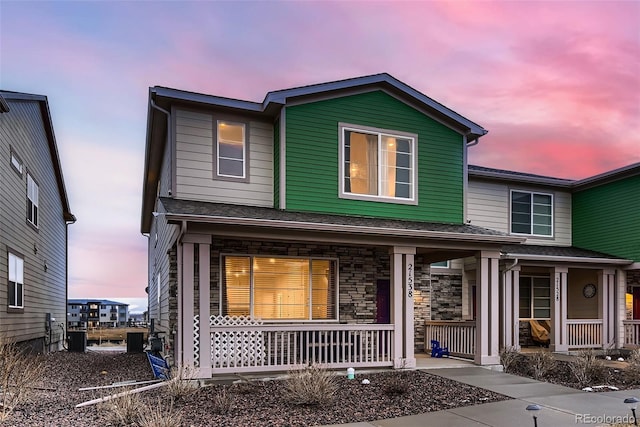 traditional-style home with covered porch and stone siding