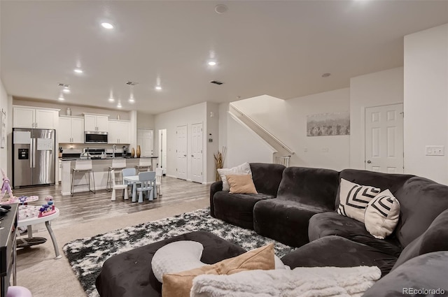 21538 E 59th Pl, Aurora, CO 80019 - living area featuring light wood-type flooring, stairs, recessed lighting, and visible vents
