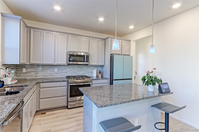 9448 Richfield St, Commerce City, CO 80022 - kitchen featuring appliances with stainless steel finishes, a sink, stone counters, decorative backsplash, and recessed lighting