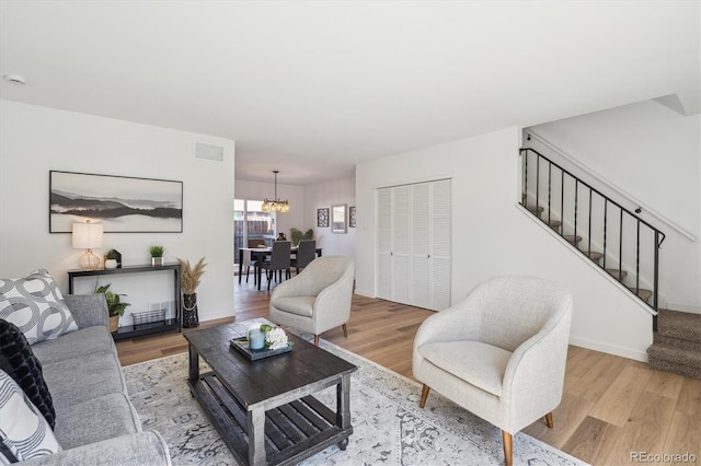 3855 S Monaco St Unit 182, Denver, CO 80237 - living area featuring stairs, wood finished floors, and a chandelier