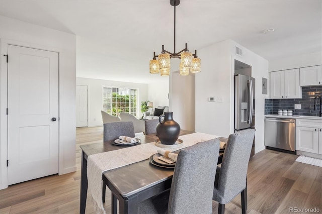 3855 S Monaco St Unit 182, Denver, CO 80237 - dining area with a chandelier and light wood-style floors