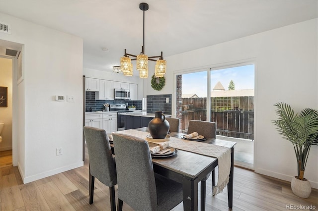 3855 S Monaco St Unit 182, Denver, CO 80237 - dining space with light wood-style flooring, baseboards, and a chandelier
