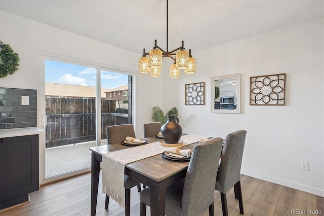 3855 S Monaco St Unit 182, Denver, CO 80237 - dining area with a chandelier, light wood finished floors, and baseboards