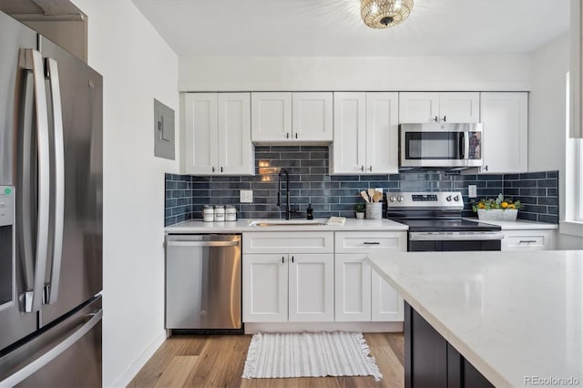 3855 S Monaco St Unit 182, Denver, CO 80237 - kitchen featuring appliances with stainless steel finishes, a sink, white cabinets, and decorative backsplash