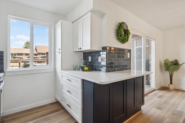3855 S Monaco St Unit 182, Denver, CO 80237 - kitchen with white cabinetry, light wood finished floors, light countertops, and baseboards