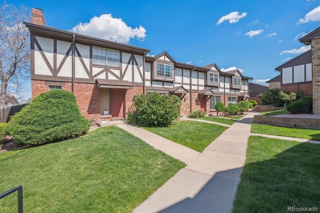 3855 S Monaco St Unit 182, Denver, CO 80237 - tudor-style house featuring stucco siding, a front lawn, a chimney, and brick siding