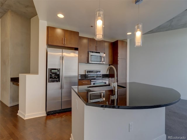 kitchen featuring decorative light fixtures, dark hardwood / wood-style floors, sink, and appliances with stainless steel finishes