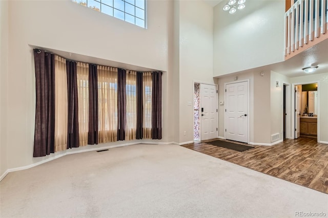 foyer with a high ceiling and wood-type flooring