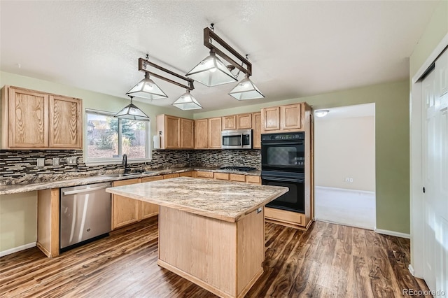 kitchen featuring a kitchen island, dark hardwood / wood-style floors, sink, pendant lighting, and appliances with stainless steel finishes