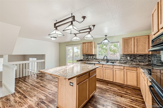 kitchen with tasteful backsplash, sink, a textured ceiling, a center island, and dark hardwood / wood-style flooring