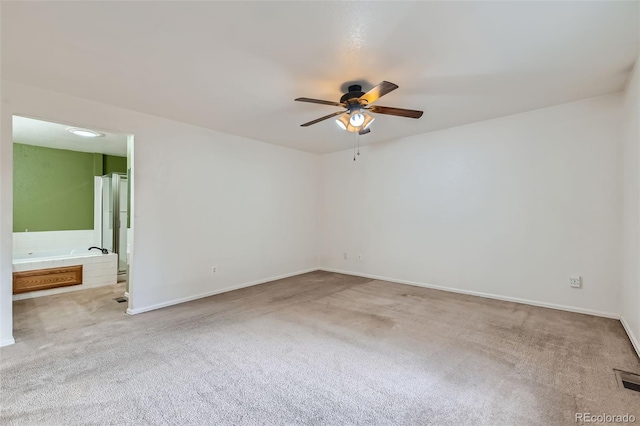 spare room featuring light carpet and ceiling fan