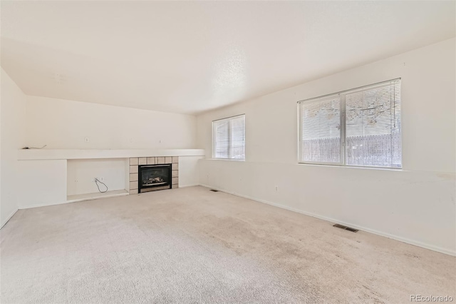 unfurnished living room featuring a fireplace and light colored carpet