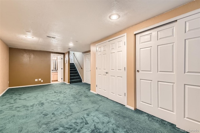 basement featuring a textured ceiling and carpet flooring