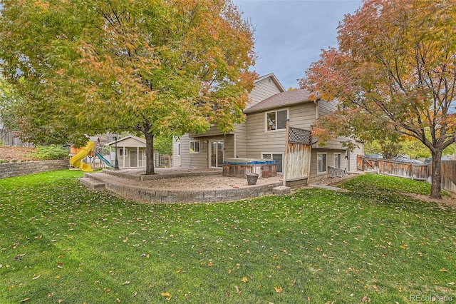 back of property featuring a yard and a playground