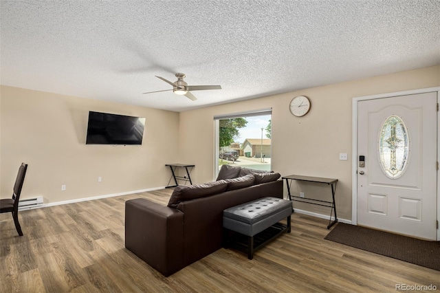 1394 S Zeno St, Aurora, CO 80017 - living area with a ceiling fan, wood finished floors, a textured ceiling, and a baseboard heating unit