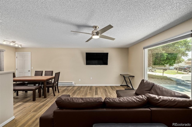 1394 S Zeno St, Aurora, CO 80017 - living area with a ceiling fan, light wood-style floors, baseboard heating, and a textured ceiling