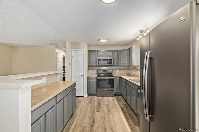 1394 S Zeno St, Aurora, CO 80017 - kitchen featuring appliances with stainless steel finishes, gray cabinets, light wood-style floors, and light countertops