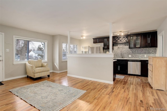 kitchen with backsplash, dark brown cabinets, light wood-type flooring, and stainless steel appliances