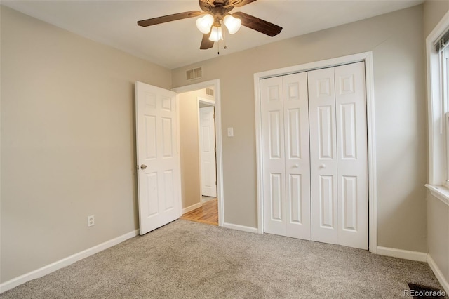 unfurnished bedroom with light carpet, a closet, and ceiling fan