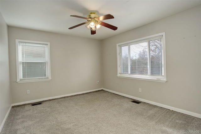 spare room featuring ceiling fan and light carpet