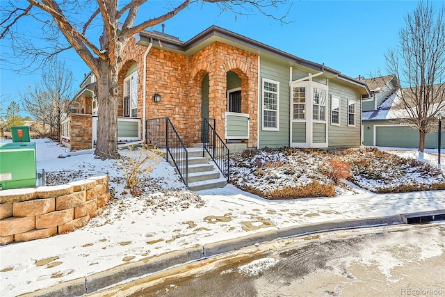 view of front of house featuring a garage and stone siding