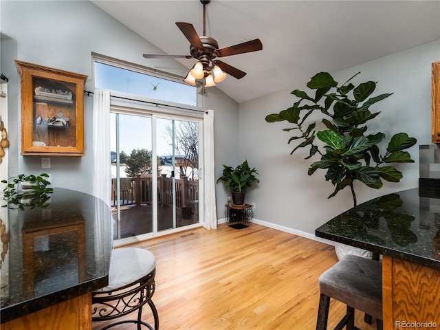 living area with lofted ceiling, light hardwood / wood-style flooring, and ceiling fan