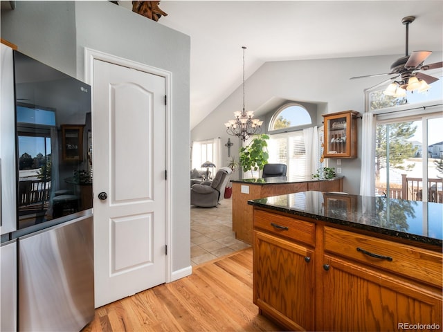 kitchen with dark stone countertops, a wealth of natural light, pendant lighting, and light wood-type flooring