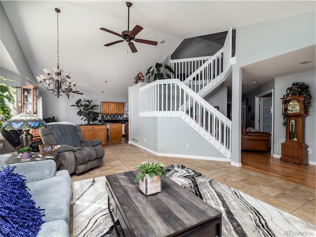 living room featuring light tile patterned floors, ceiling fan with notable chandelier, and high vaulted ceiling