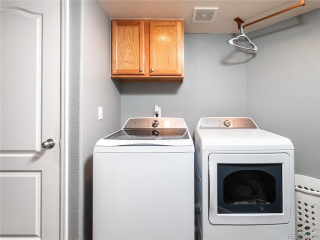 washroom with cabinets and washer and clothes dryer