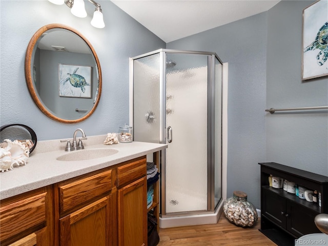 bathroom featuring vanity, wood-type flooring, and walk in shower