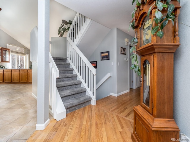 stairs with wood-type flooring and vaulted ceiling