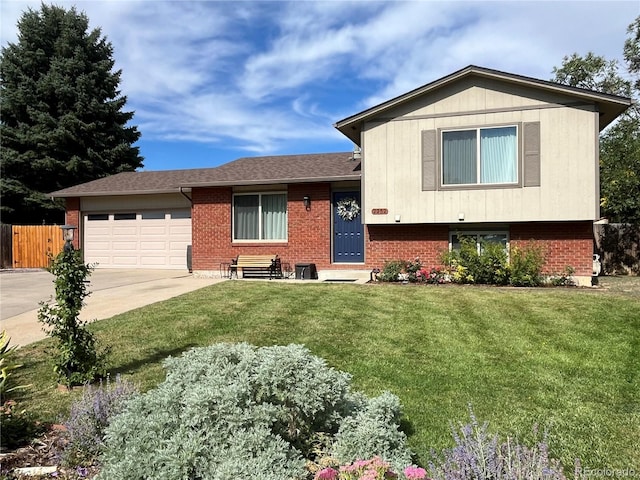 split level home featuring an attached garage, brick siding, fence, concrete driveway, and a front yard