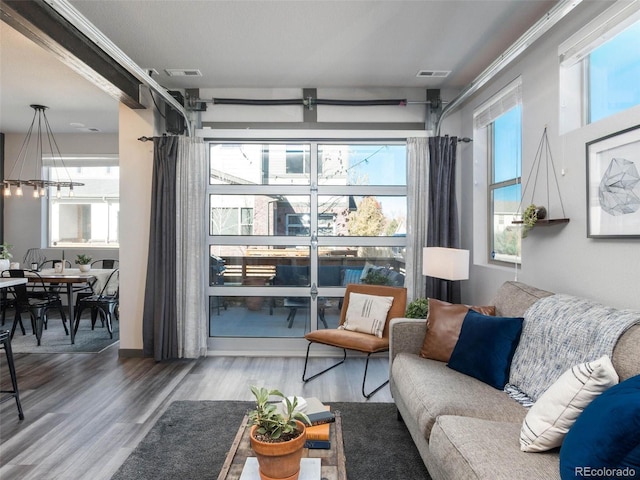 sitting room featuring plenty of natural light, wood finished floors, and visible vents