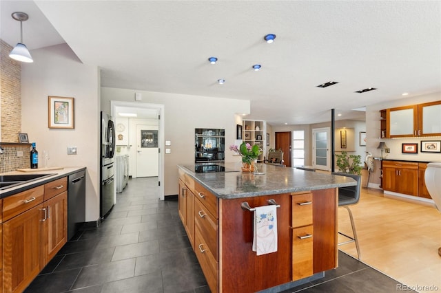 831 Crescent Dr, Boulder, CO 80303 - kitchen featuring dishwashing machine, stainless steel fridge, a breakfast bar area, and brown cabinetry