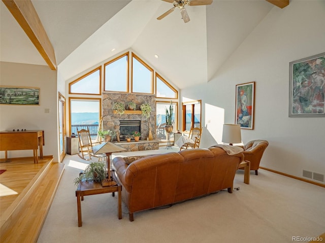 living room with a stone fireplace, high vaulted ceiling, and ceiling fan