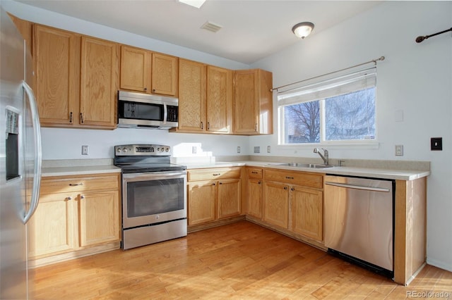 kitchen featuring light wood-type flooring, appliances with stainless steel finishes, and sink