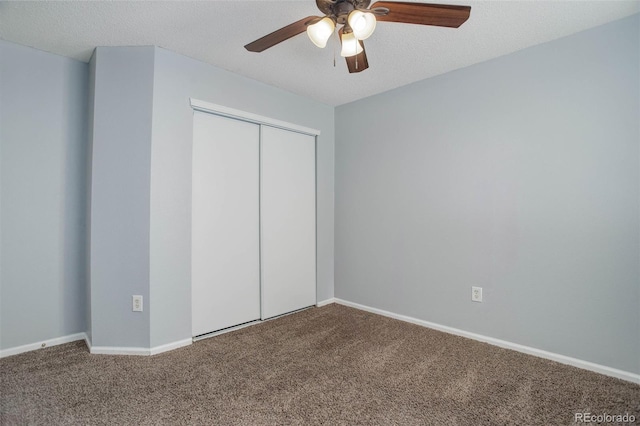 unfurnished bedroom with ceiling fan, a closet, a textured ceiling, and carpet flooring