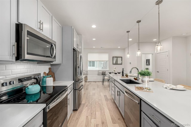 2052 Alcott Way, Broomfield, CO 80023 - kitchen featuring appliances with stainless steel finishes, a sink, gray cabinets, light wood-style flooring, and light countertops