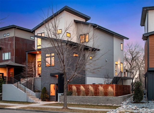 view of front of house featuring stairway and fence