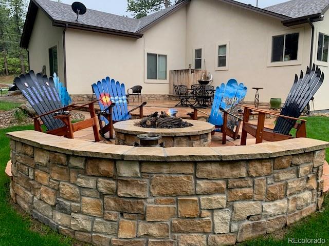 rear view of property featuring an outdoor fire pit and a patio area