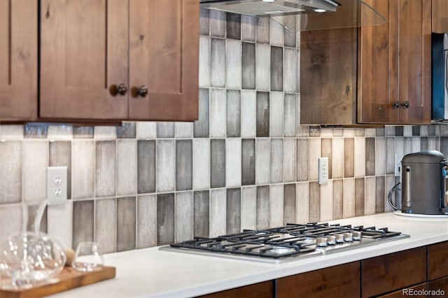 kitchen with exhaust hood, stainless steel gas cooktop, and backsplash