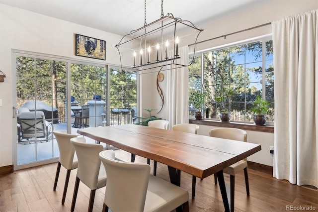 dining room with an inviting chandelier and wood-type flooring