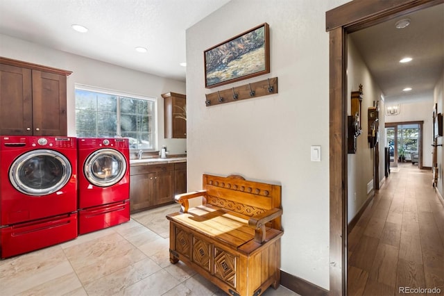 laundry area with sink, cabinets, and washer and clothes dryer