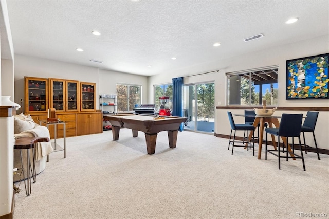 rec room with a textured ceiling, billiards, and light carpet